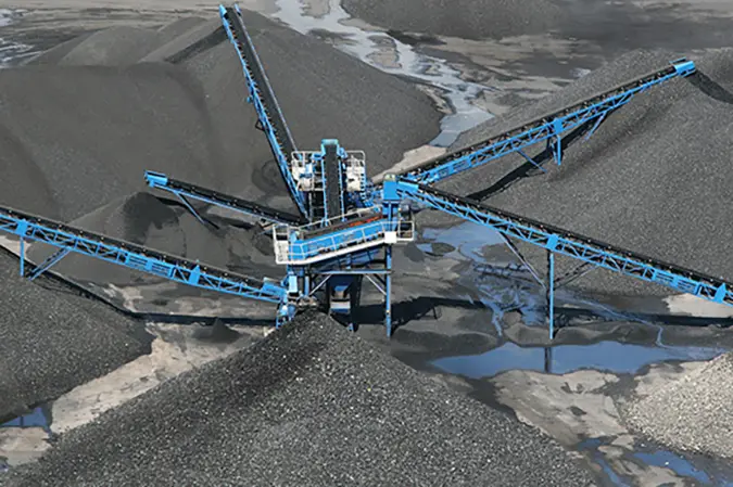 Aerial photo of mining conveyor machinery unloading piles of aggregate material