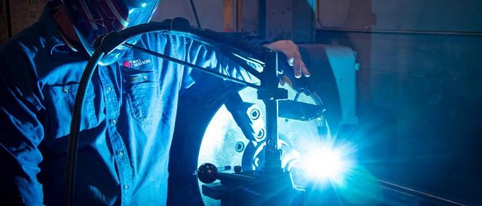 Motion Service & Repair technician welding and re-manufacturing a motor while wearing personal protective equipment