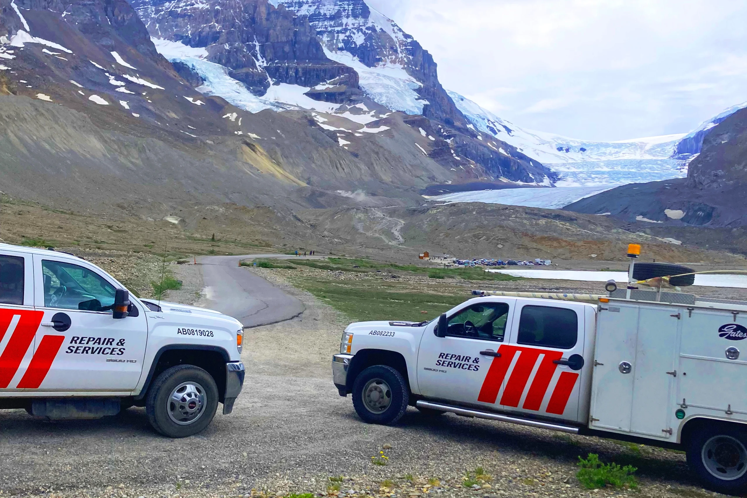 Two white Motion Repair & Services trucks at mountain location