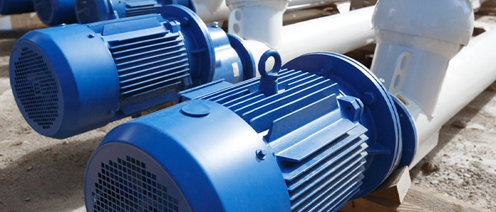 Several blue and white powder coated motors connected to pipes as part of a larger machine.
