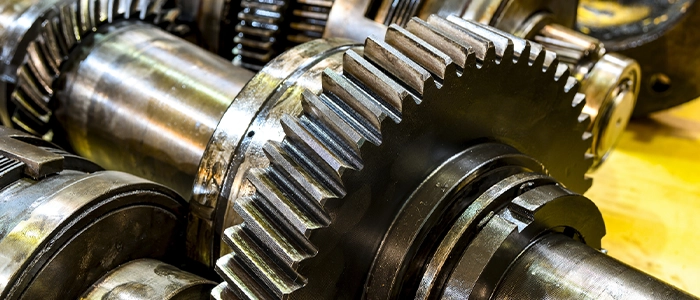 Several large gears of various shapes and sizes are laid out on a table, awaiting assembly.